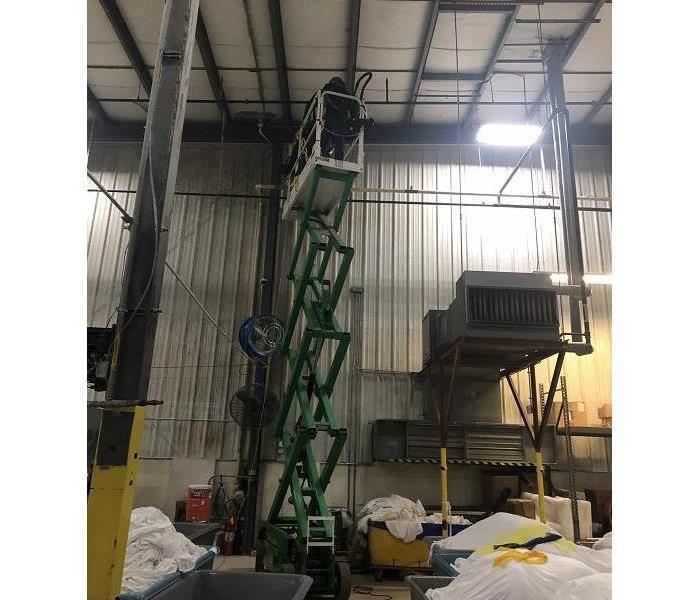 Photo of crew member cleaning high walls in warehouse