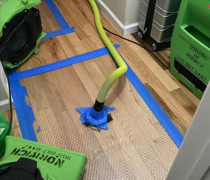 Water removal under the flooring in a hallway of a home.