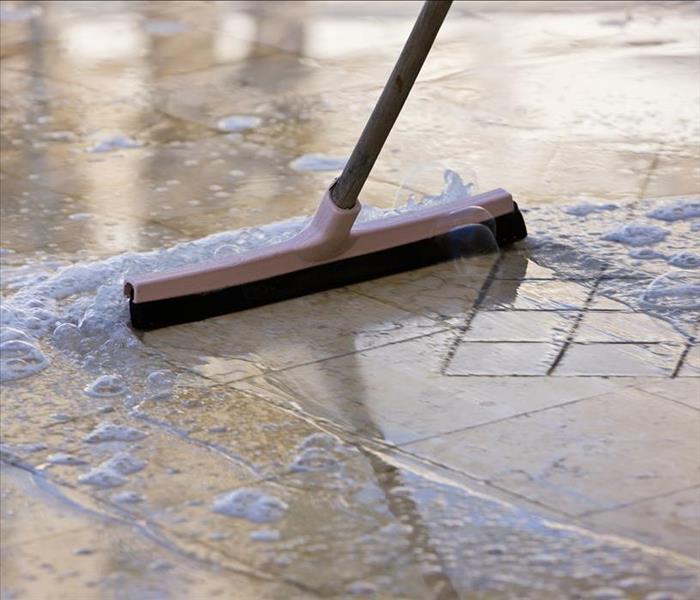 squeegee moving water over tile